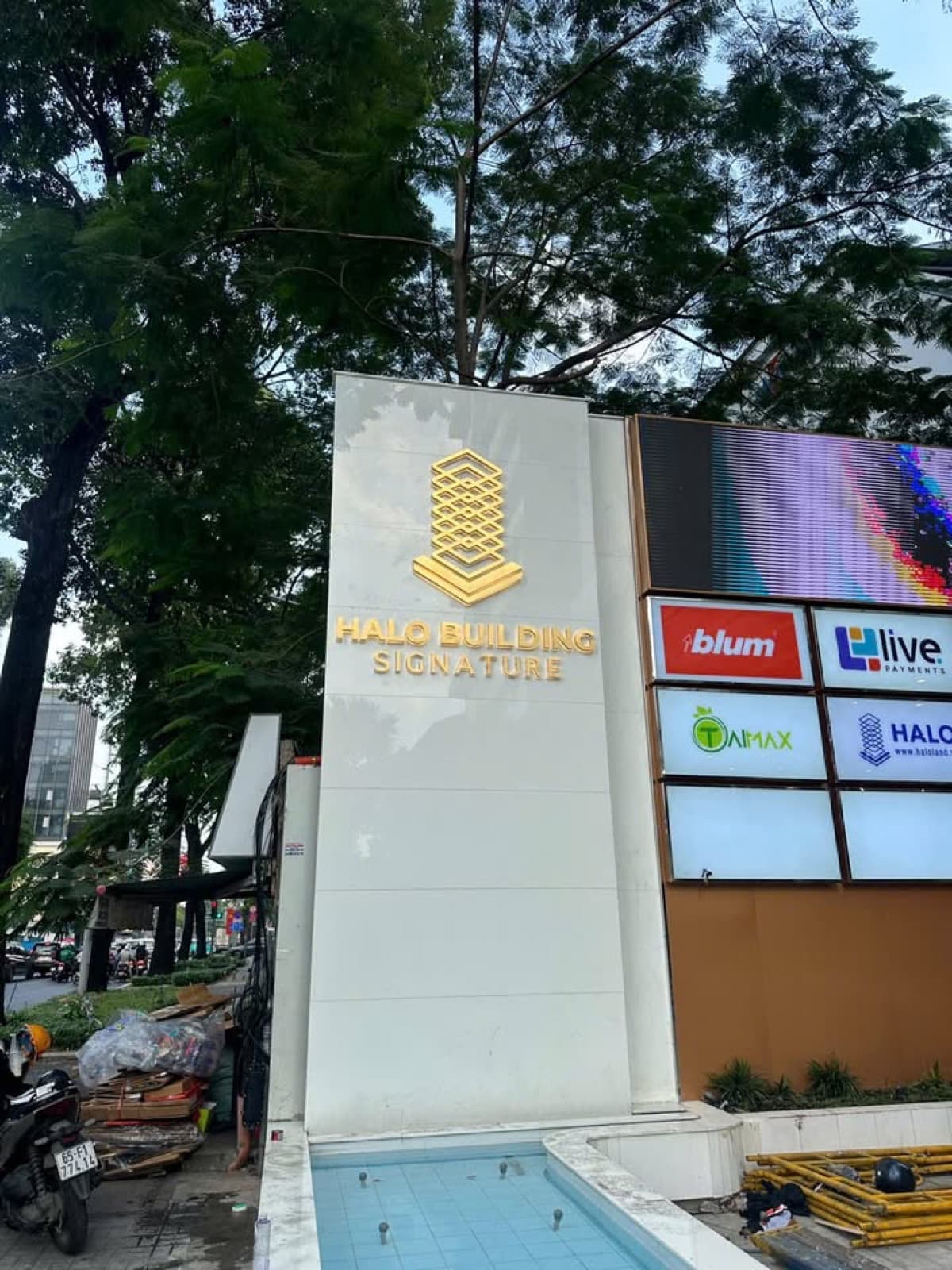 Biển tên HALO BUILDING SIGNATURE cạnh bảng hiển thị logo các đơn vị