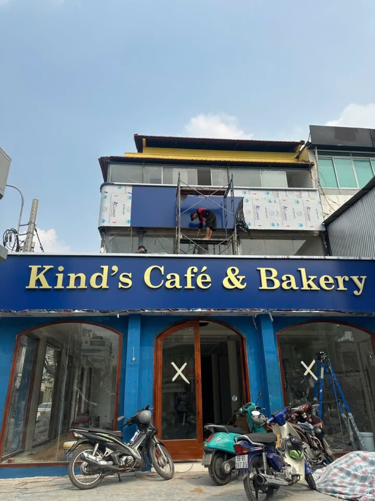Mặt tiền Kind’s Café & Bakery có giàn giáo và vật liệu che phủ ở tầng trên