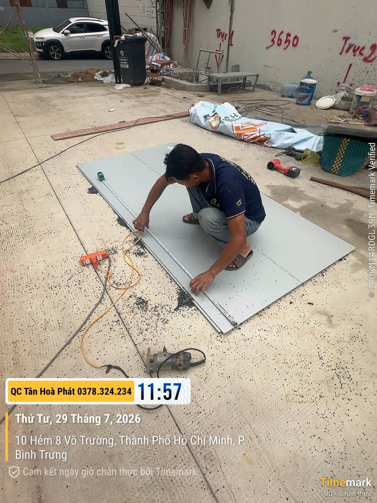 Người thợ đo tấm vật liệu bằng thước, cạnh máy khoan và dụng cụ
