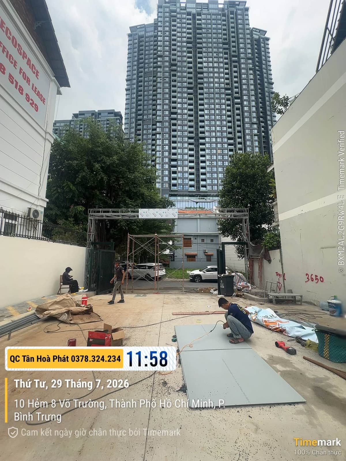 Người thợ thao tác trên các tấm vật liệu đặt dưới nền, phía trước là khung kim loại